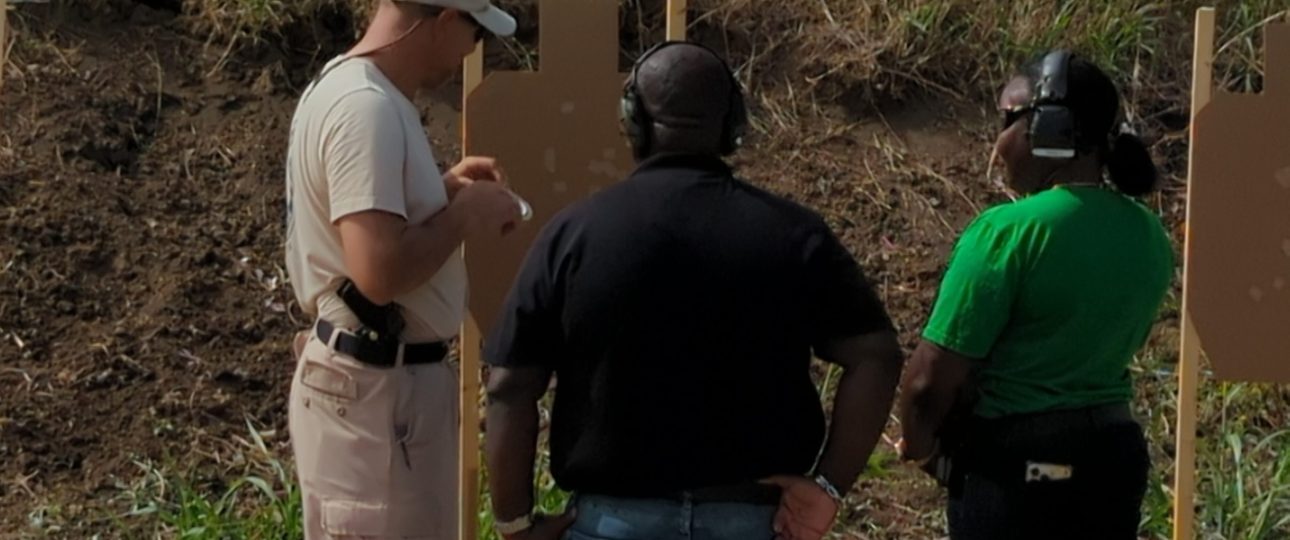 Instructor talking to a married couple about their targets. They are taking a handgun training class at Urban Defense Academy.
