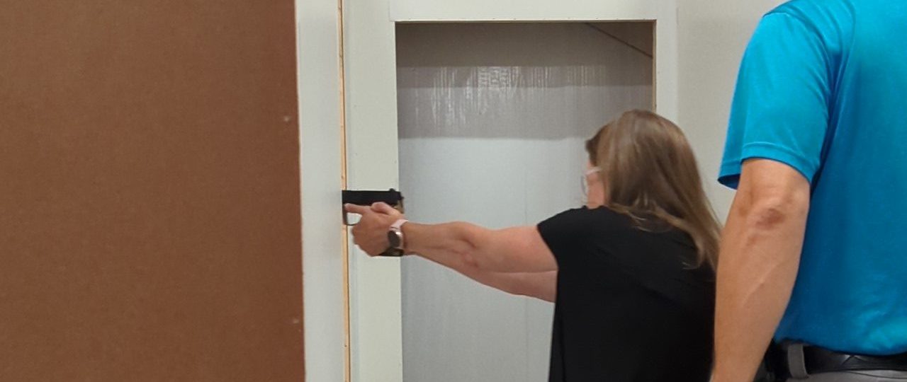 Woman learning to search, clear and secure and area, such as her home, during the Practical Pistol Course Series at Urban Defense Academy in Liberty Hill Texas